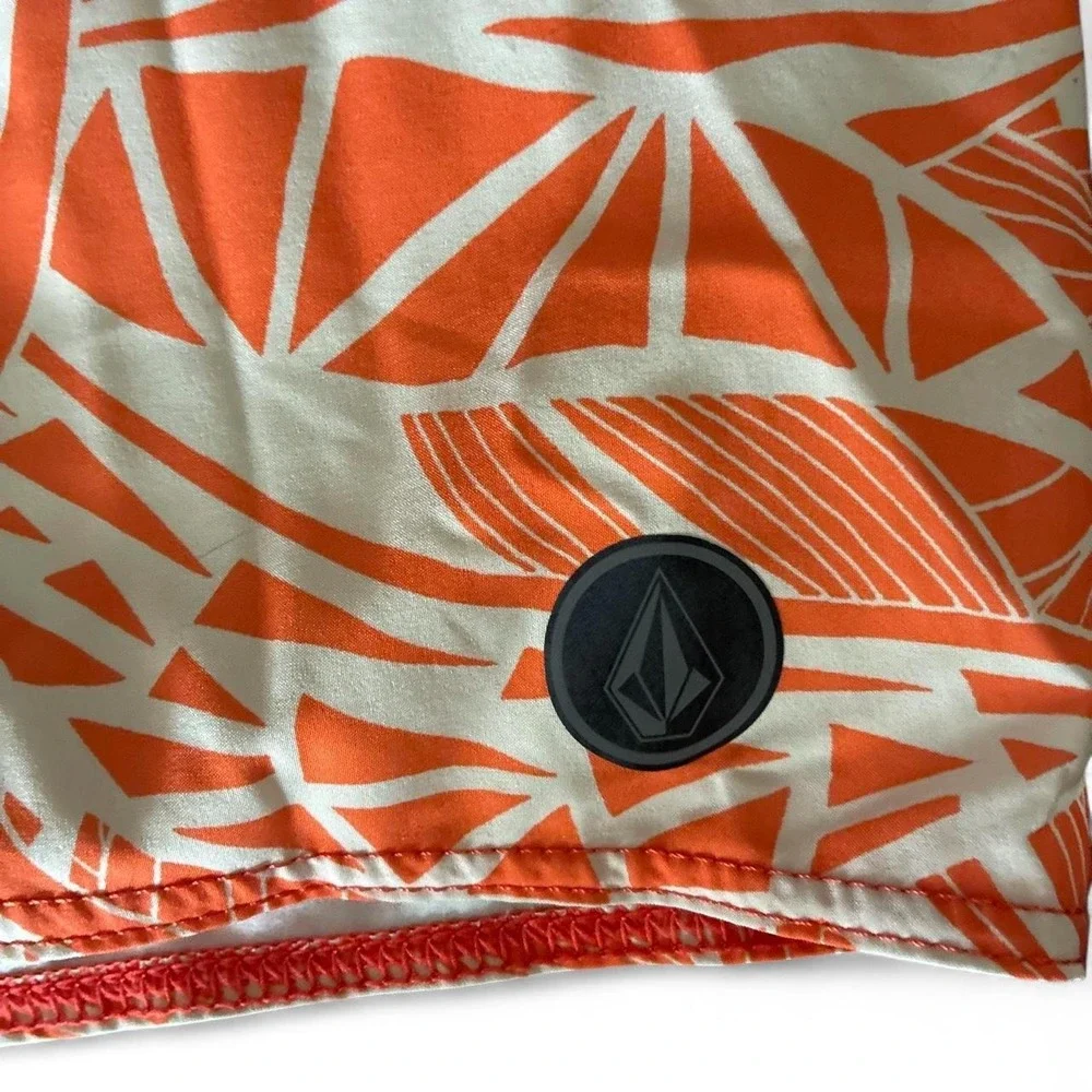 Preowned 2015 Volcom board shorts with orange, white, and black abstract